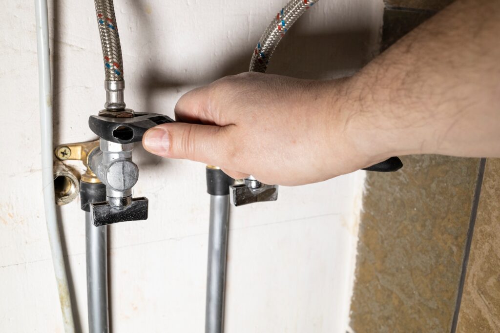 hand installs water stop tap by adjustable wrench